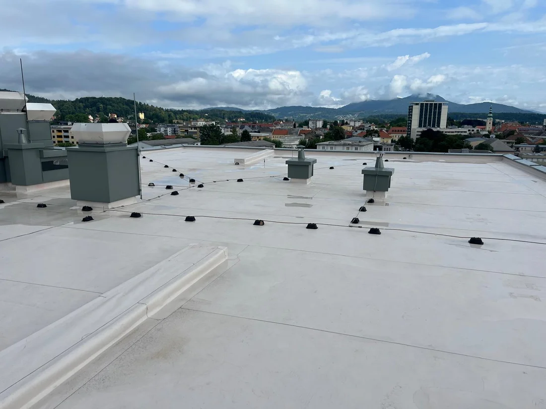 Blick über die helle Dachfläche und die eingefassten Aufbauten – Flachdach mit Anschlussdetails