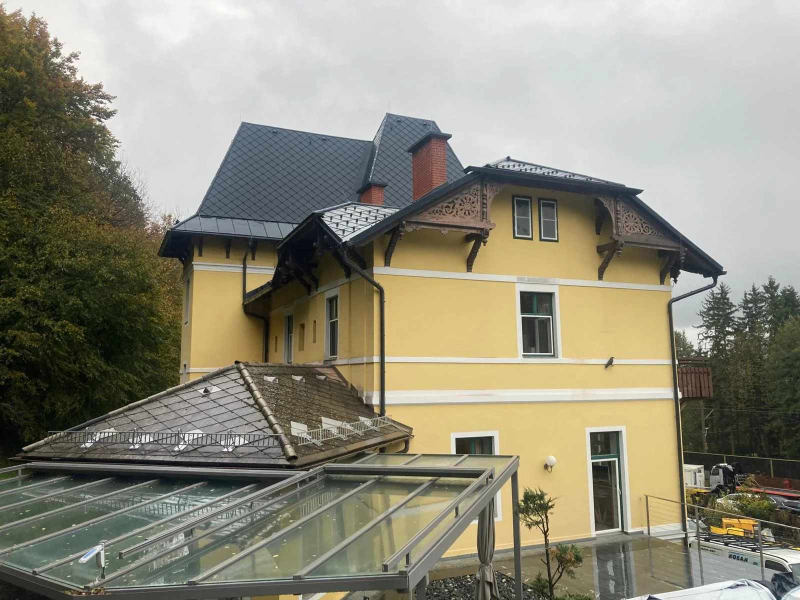Gelbes historisches Wohnhaus mit grauer Rautendeckung an den steilen Dachflächen