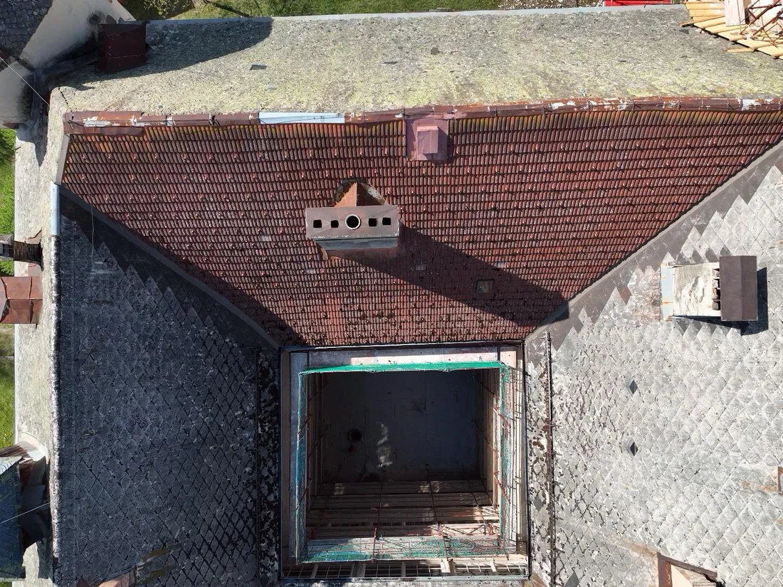 Blick von oben auf den Innenhof und die unterschiedlich gedeckten Dachflächen – Schloss Tentschach